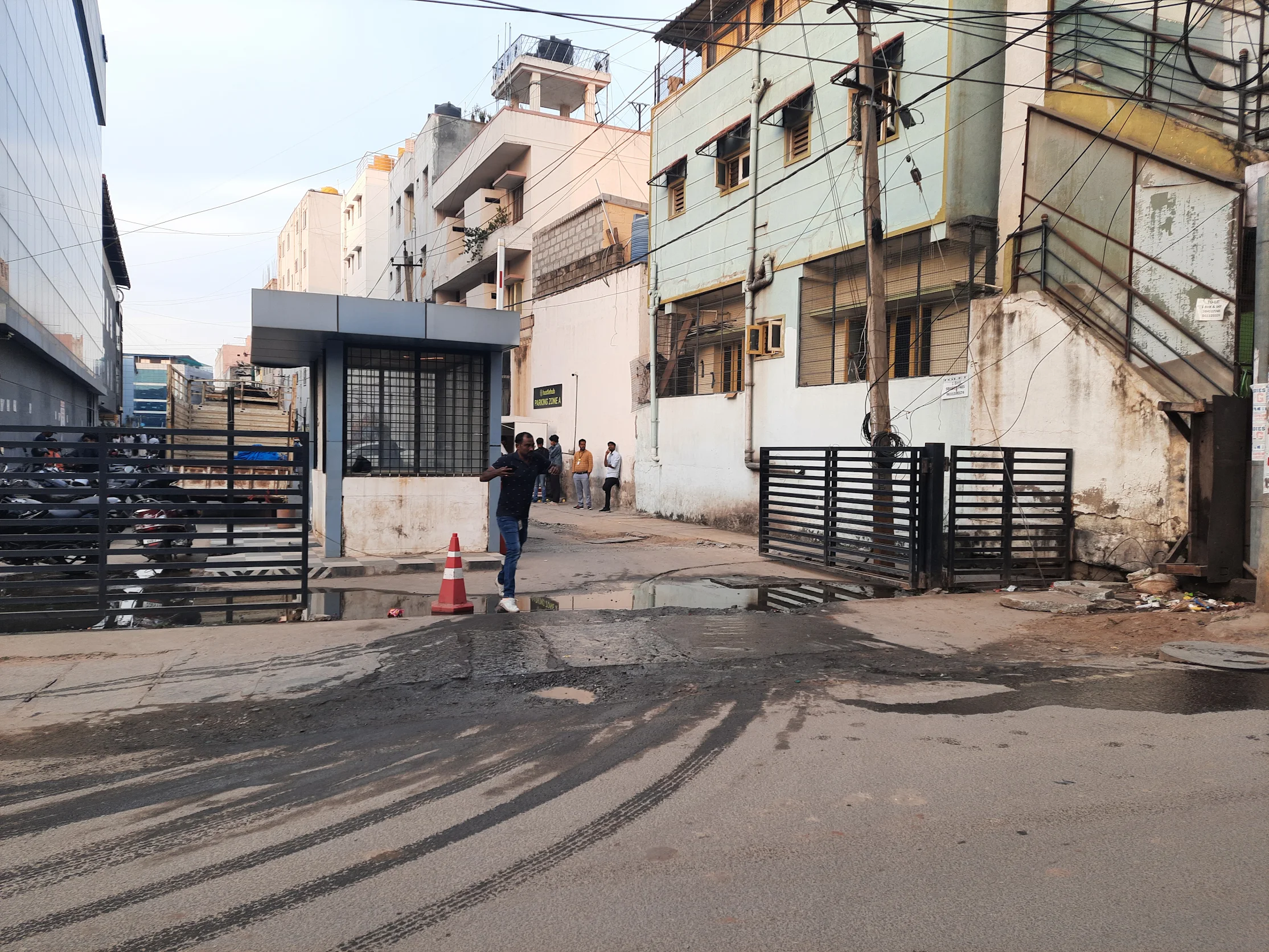 Standing dirty water and trash at the HustleHub parking entrance gate